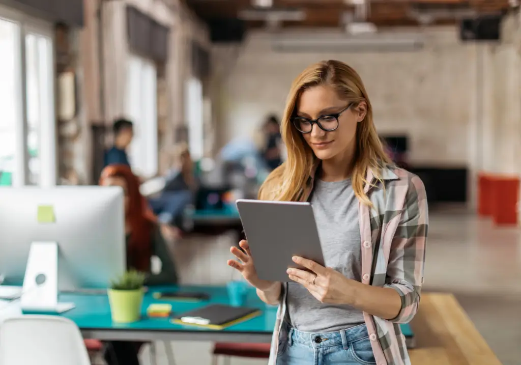 Data analyst reviewing AI-powered business insights on multiple computer screens.